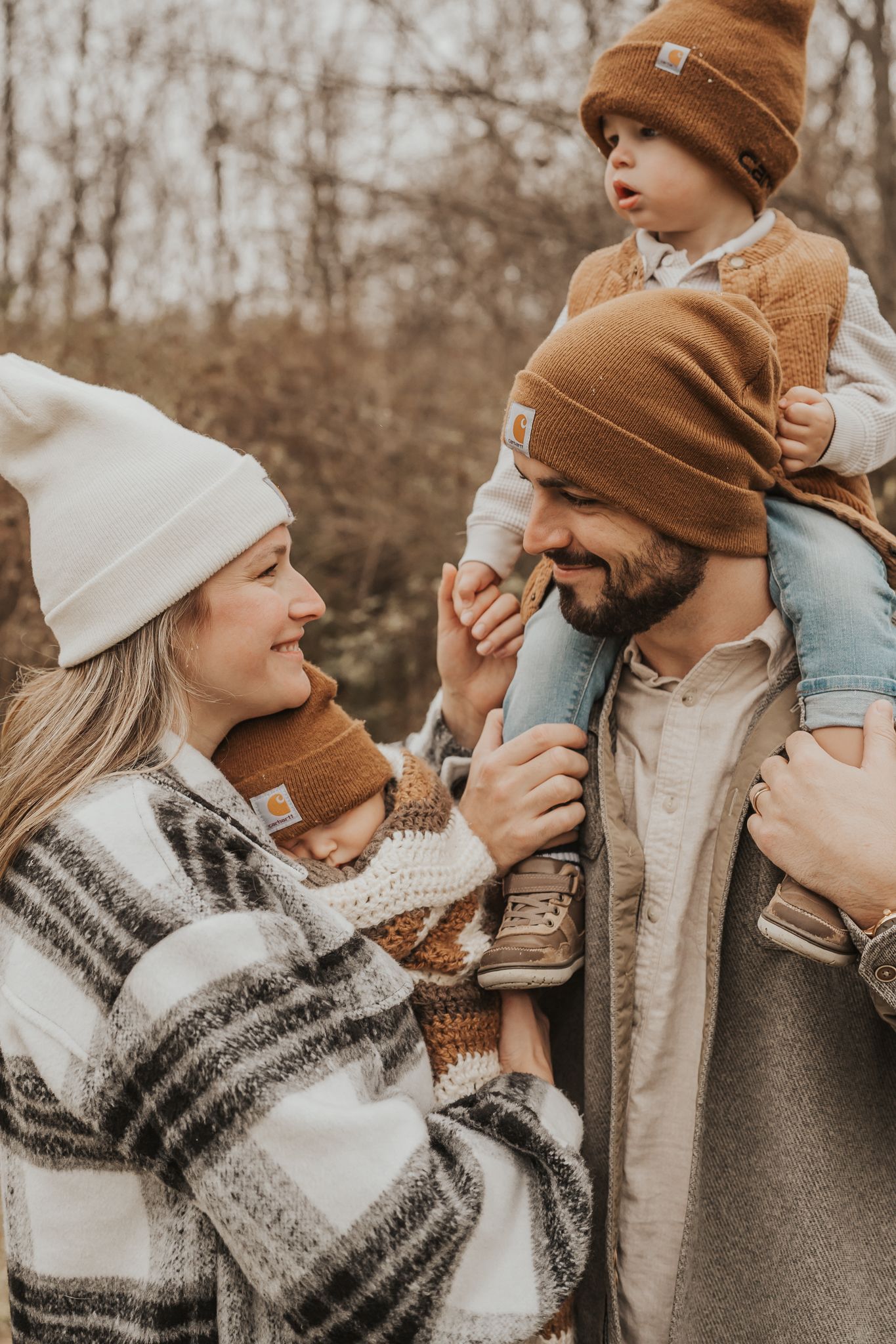 Intimate Michigan family moment photographed outdoors wearing cozy winter accessories.