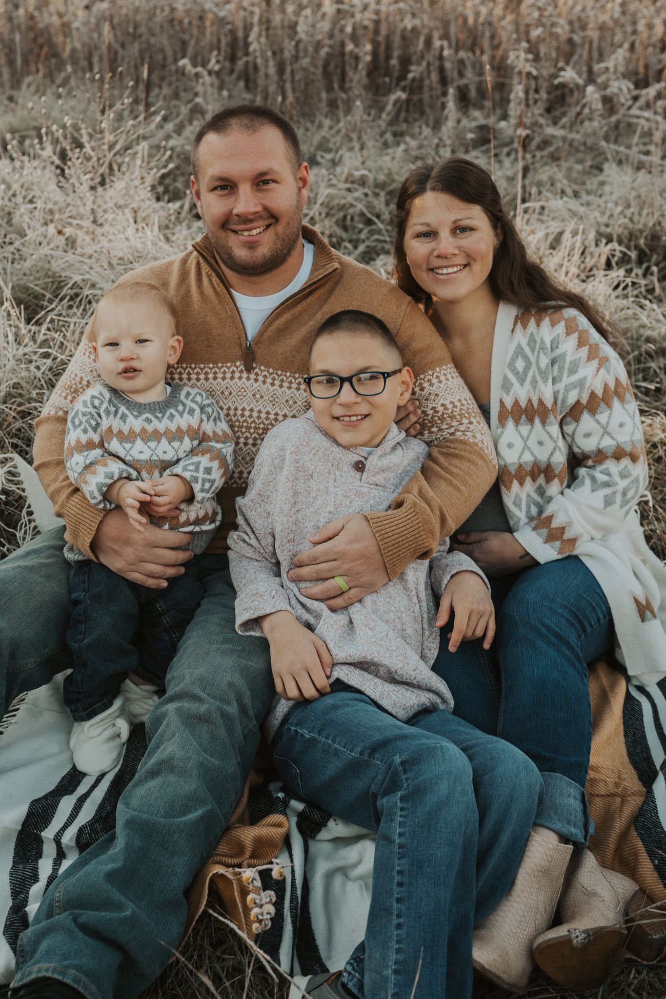 Casual family portrait in coordinating sweaters sitting together outdoors in Pulaski Michigan.