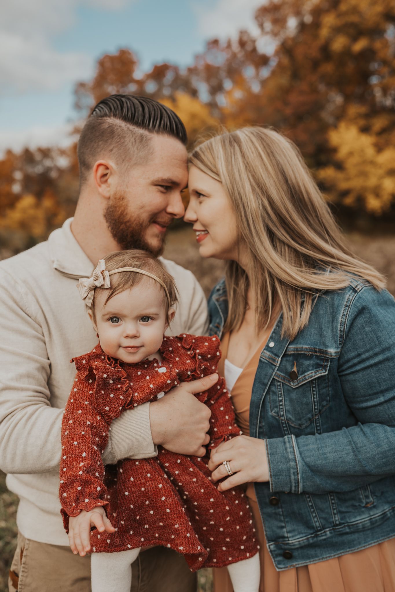 A loving family shares an intimate moment together during an autumn photoshoot outdoors.