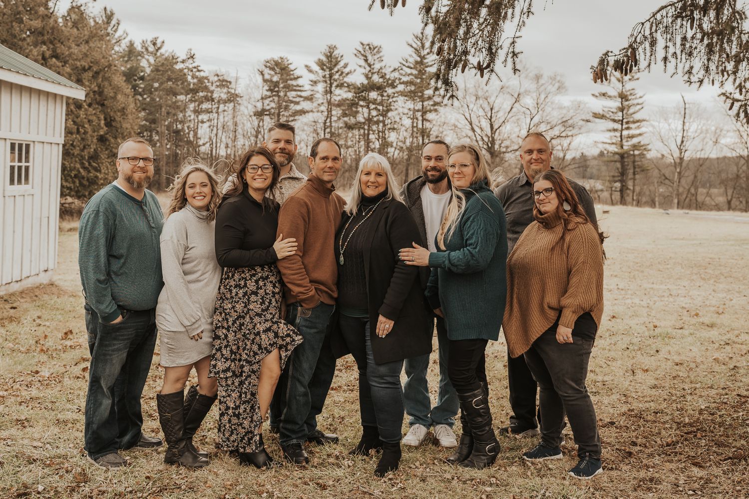 Extended family portrait of family members wearing coordinated autumn colors outdoors taken in Michigan.