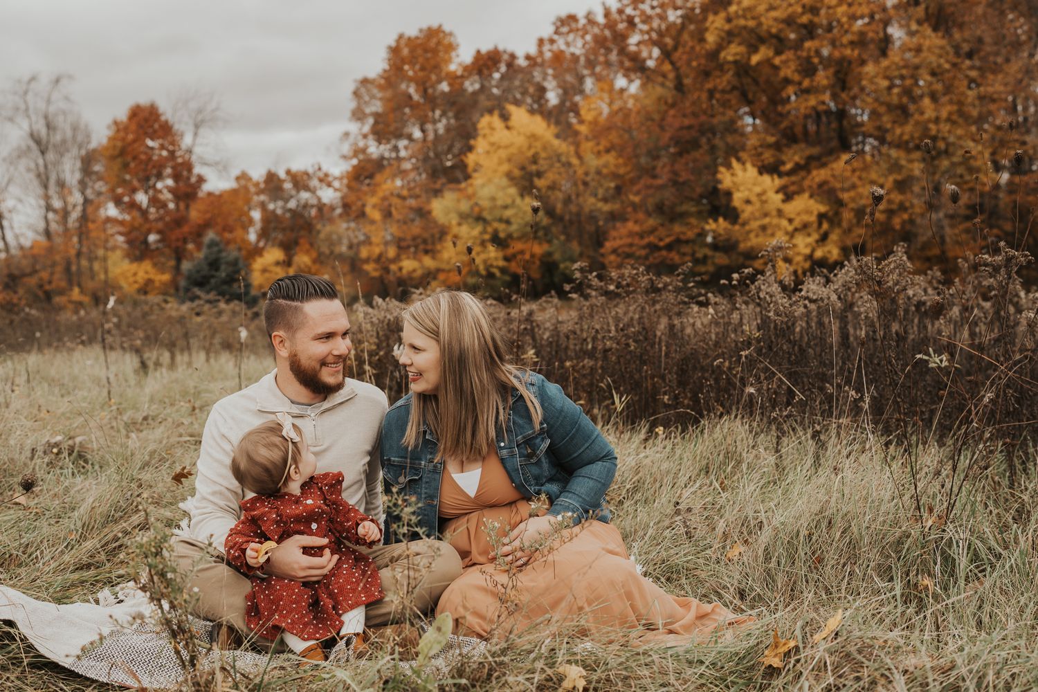 Candid family moments in a fall field with golden autumn colors.