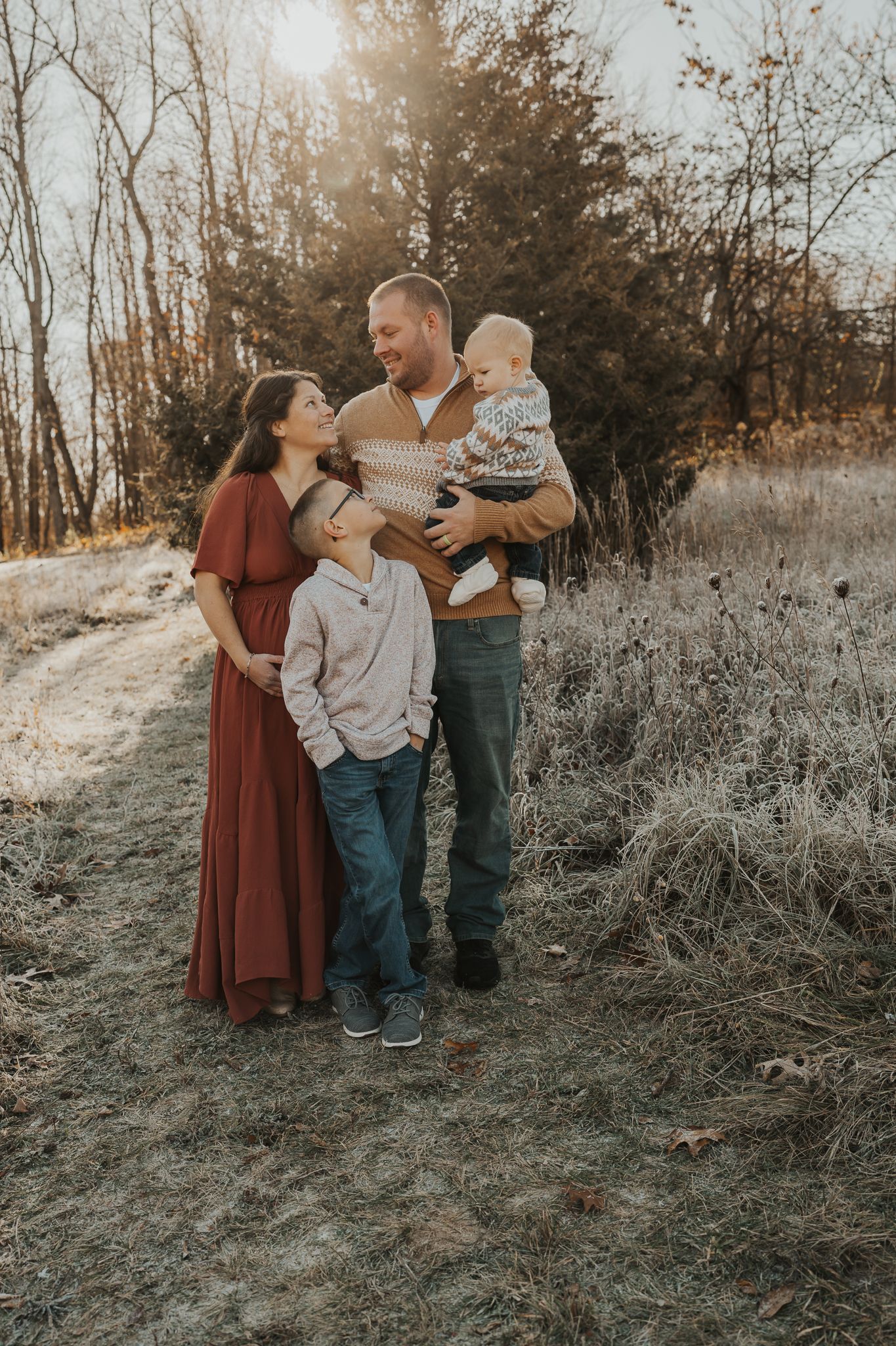 Family sharing tender moments together in a natural winter outdoor setting during golden hour.