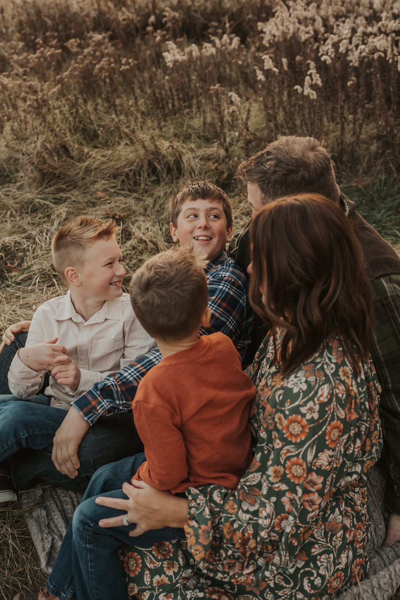 Candid family moment showing playful interaction and laughter in a natural outdoor setting.