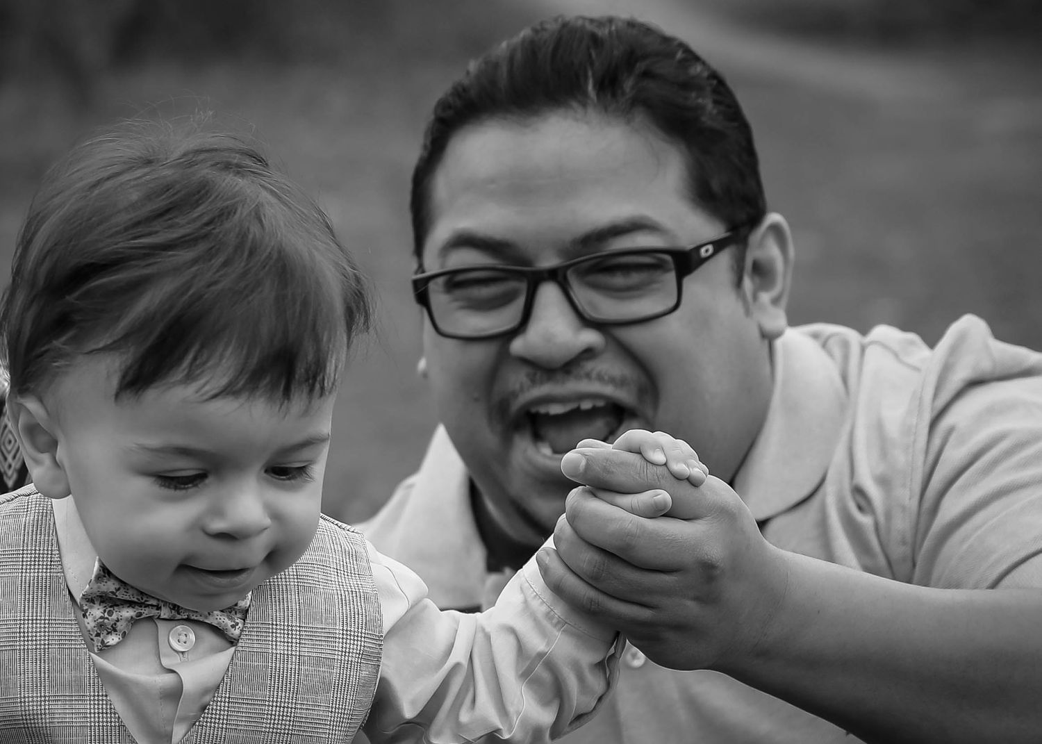 A family shares affectionate moments together during a springtime photo session. Family photoshoot. L. Visions Photography. Father and son.