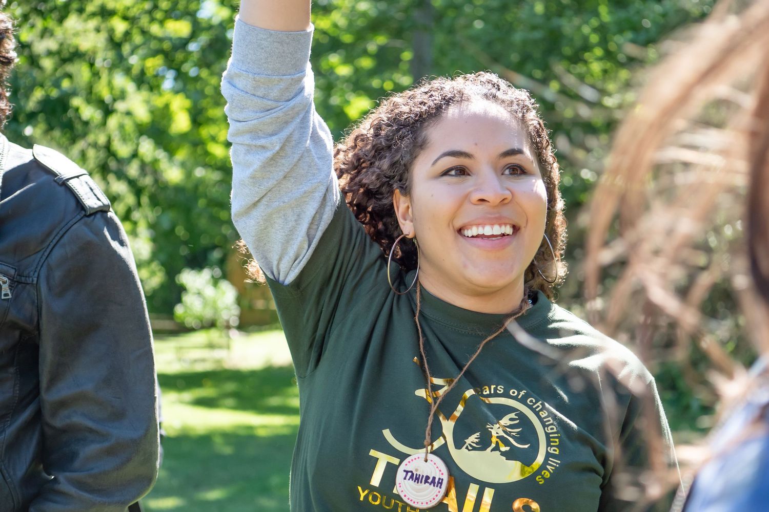 Woman waving and smiling on a sunny day.