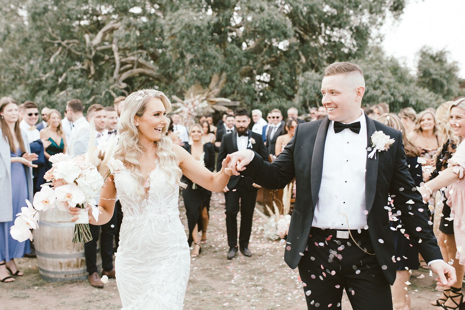 Wedding party celebration with confetti shower in outdoor garden venue.