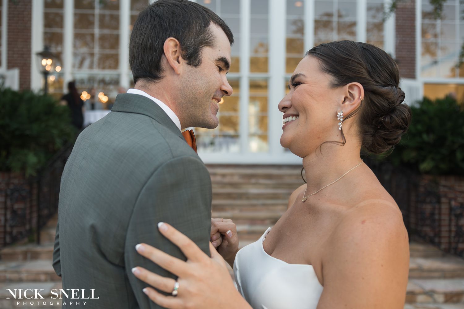 A candid moment of joy shared between newlyweds on outdoor steps.