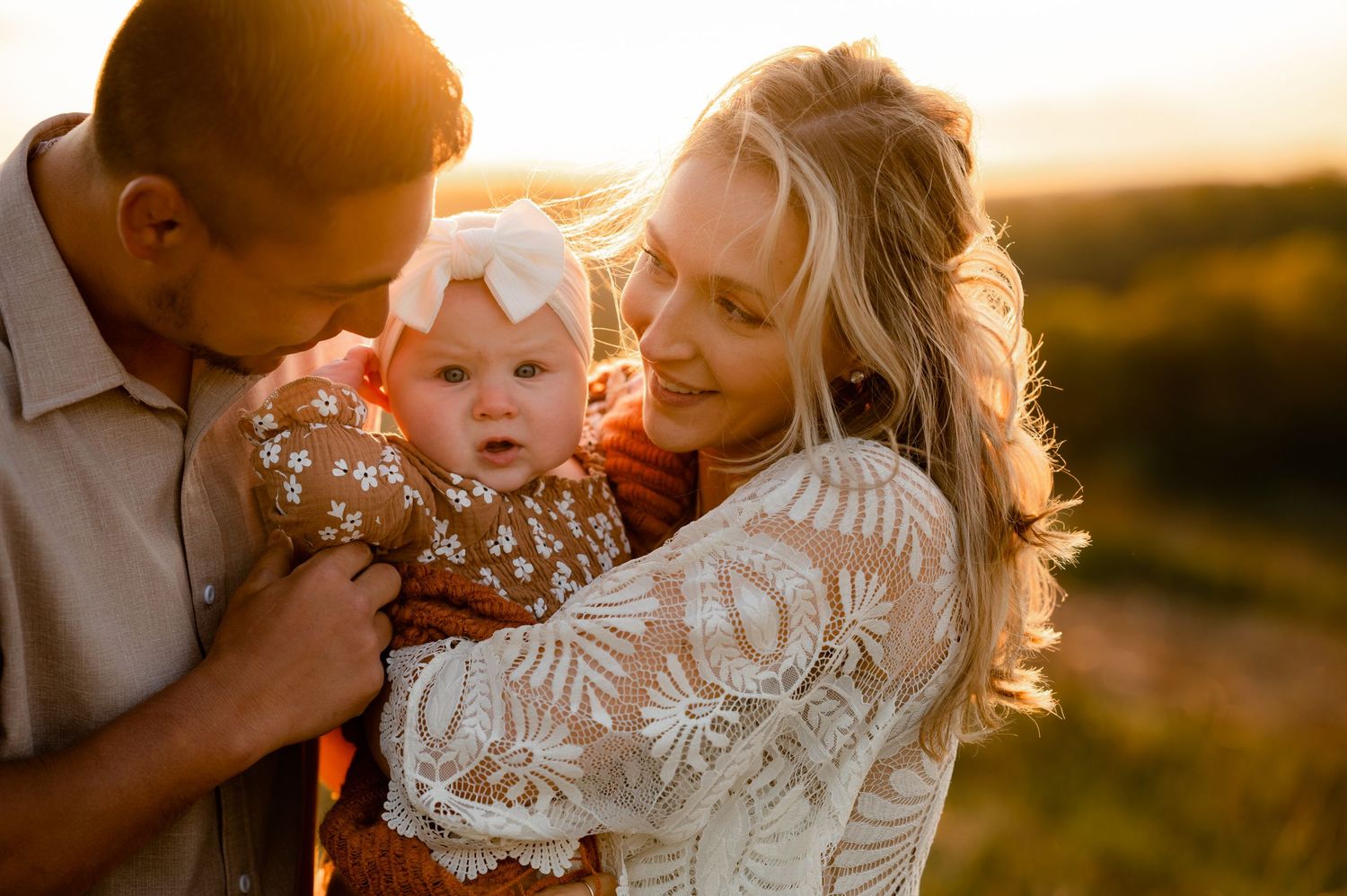 parents snuggling baby during golden hour created by Storms Photography Pennsylvania photographer