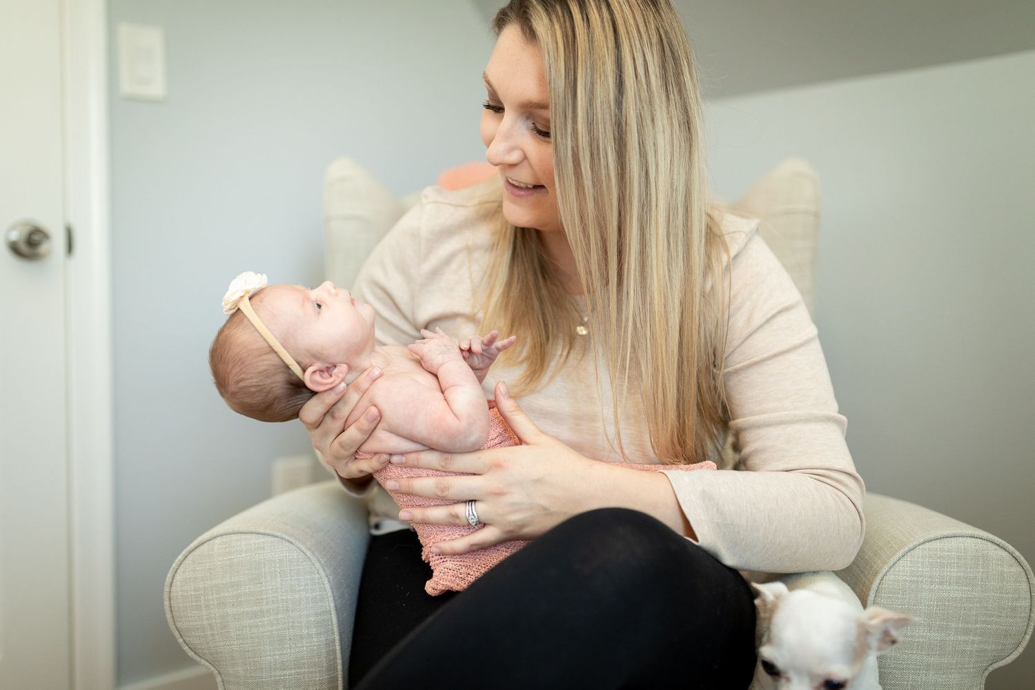 Sweet interaction with baby wearing peach-colored outfit in nursery room.