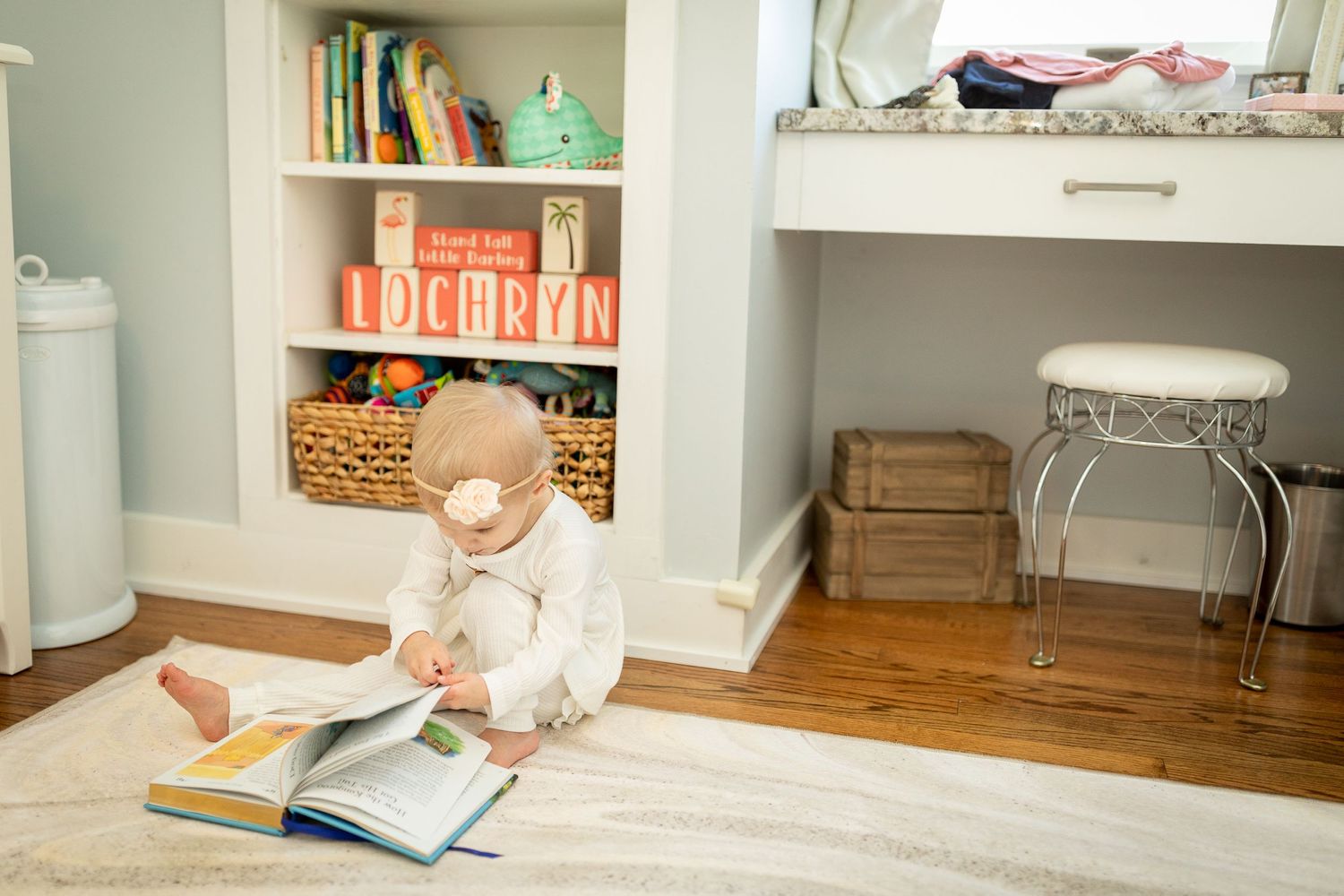 A bright and airy nursery room with pale blue walls, white furniture, and soft pink accents.