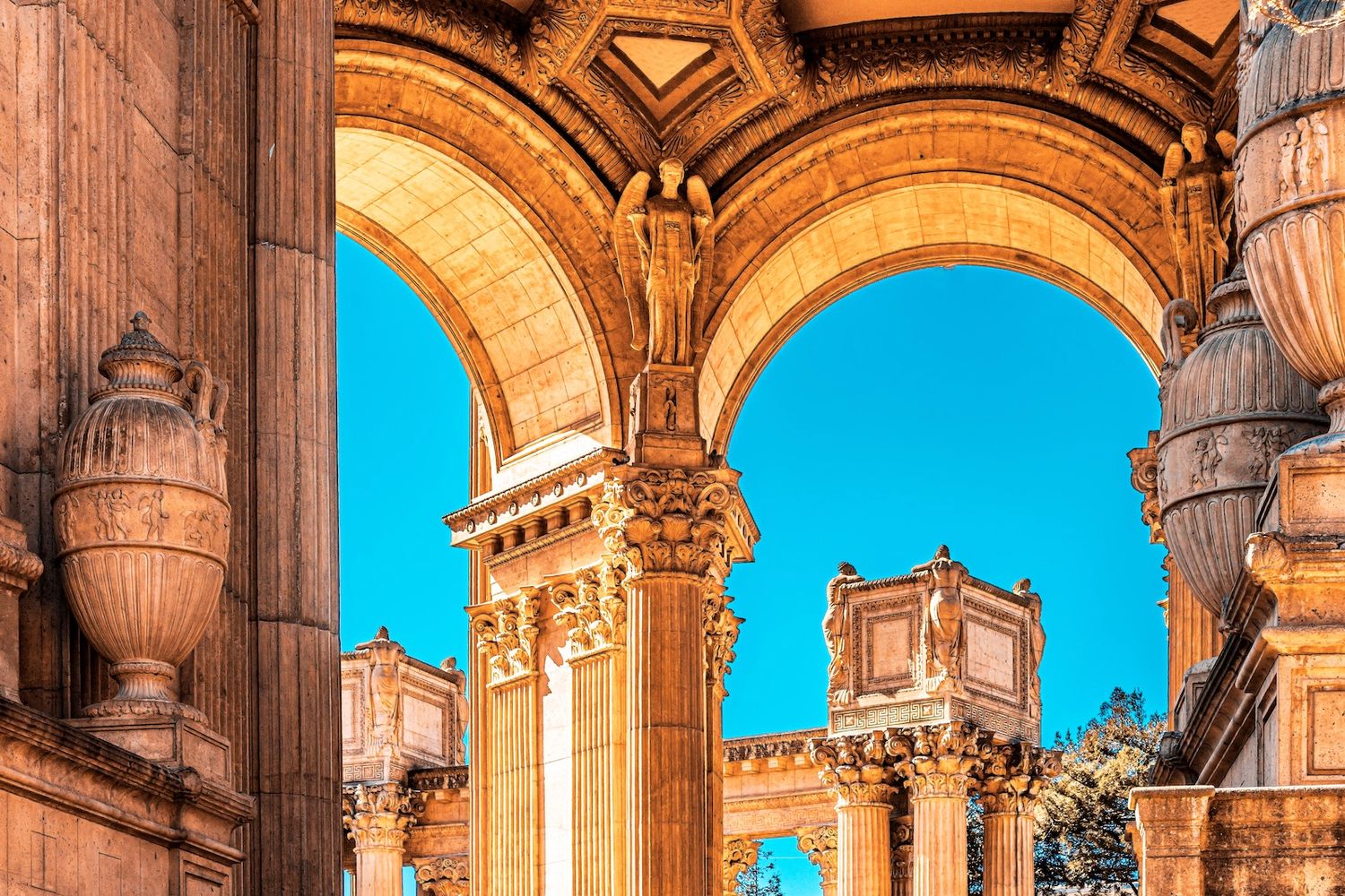 San Francisco Palace of Fine Arts with a bright blue sky visible through the openings.