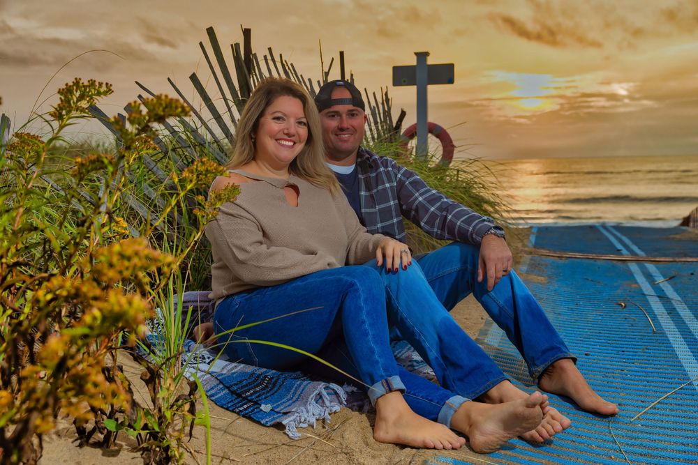 Beach photoshoot featuring couple relaxing on blue blanket during golden hour.