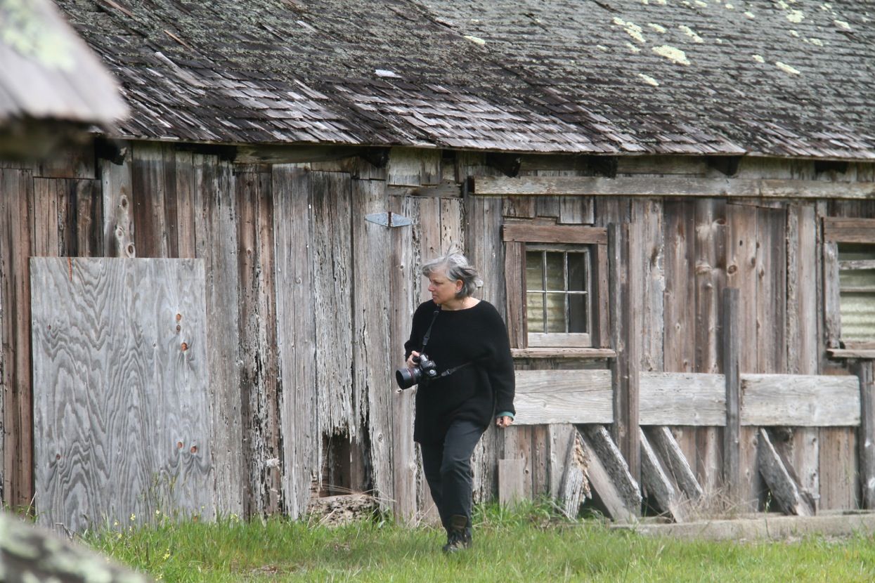 Joyce Perlman walking with camera in hand at Spring Ranch loving the barn textures. Photography by Debi Lorenc