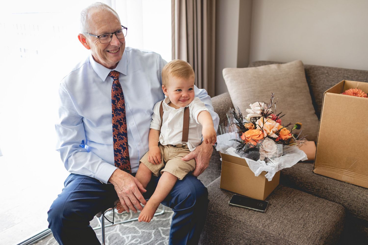 Formal family moment with floral arrangement on side table.