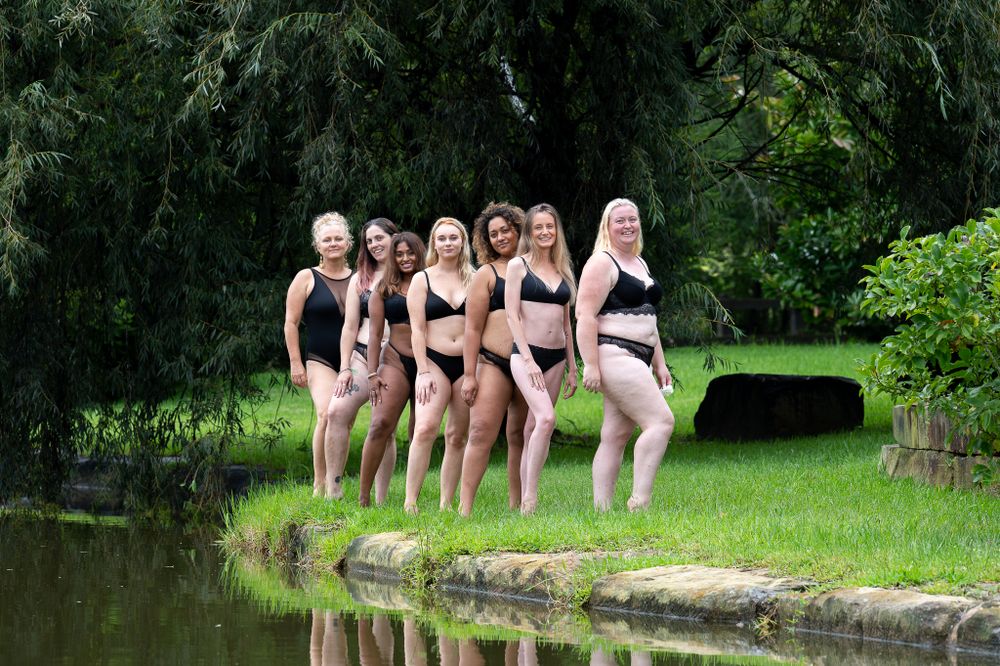 Ladies empowered posing by the water dressed in black lingerie