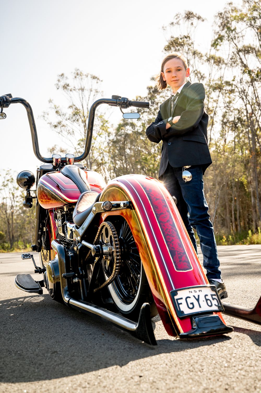 Year 6 formal boy posing by low rider motorbike