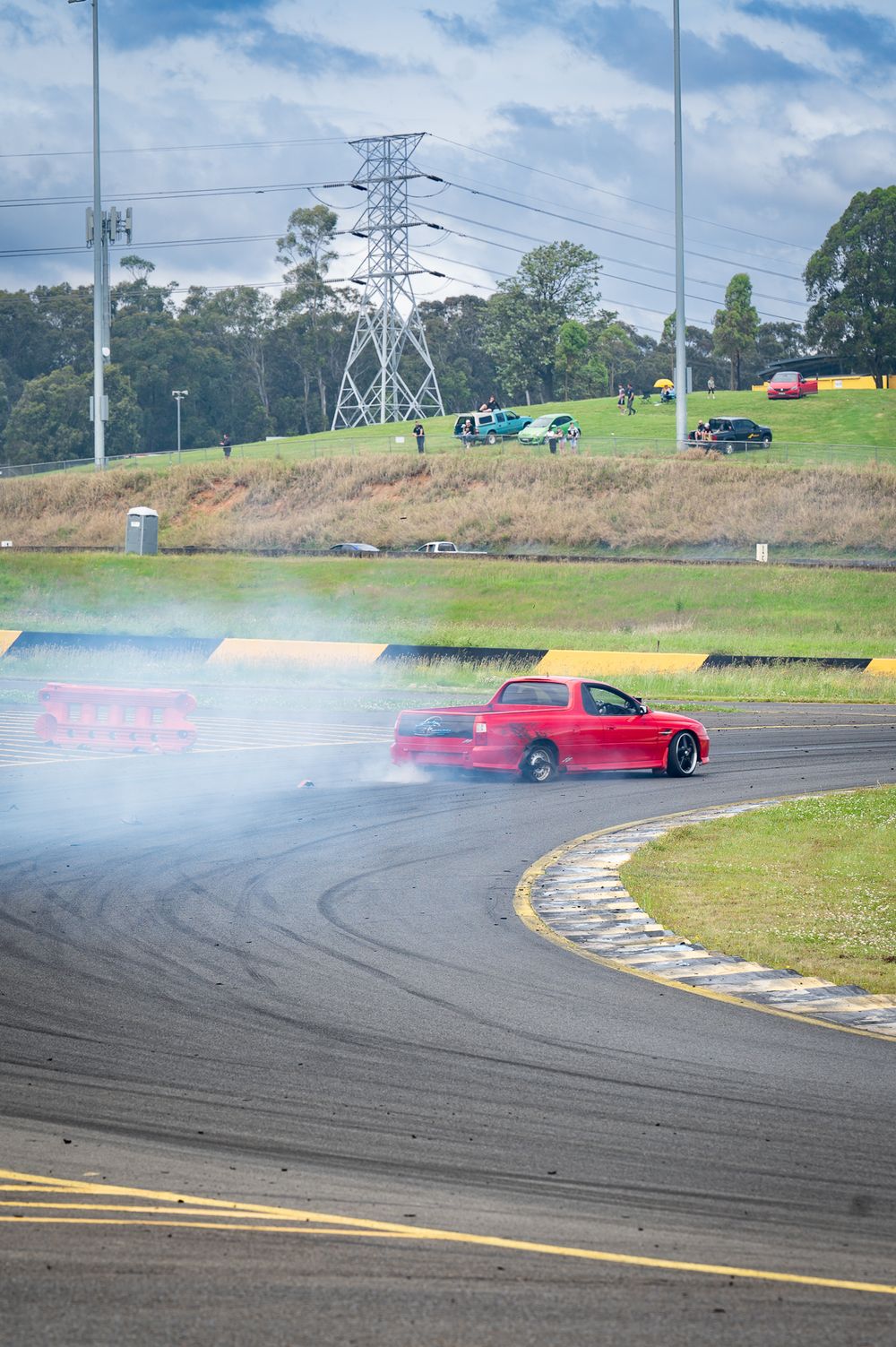 Red car doing burnout on the race track