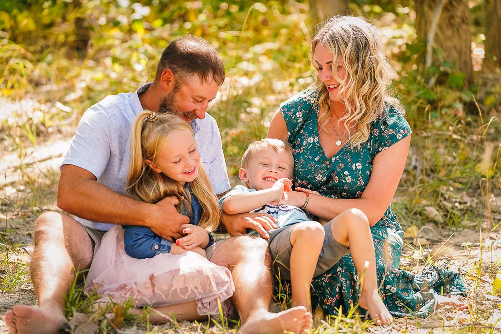 Family enjoying outdoor photo session in autumn sunlight.