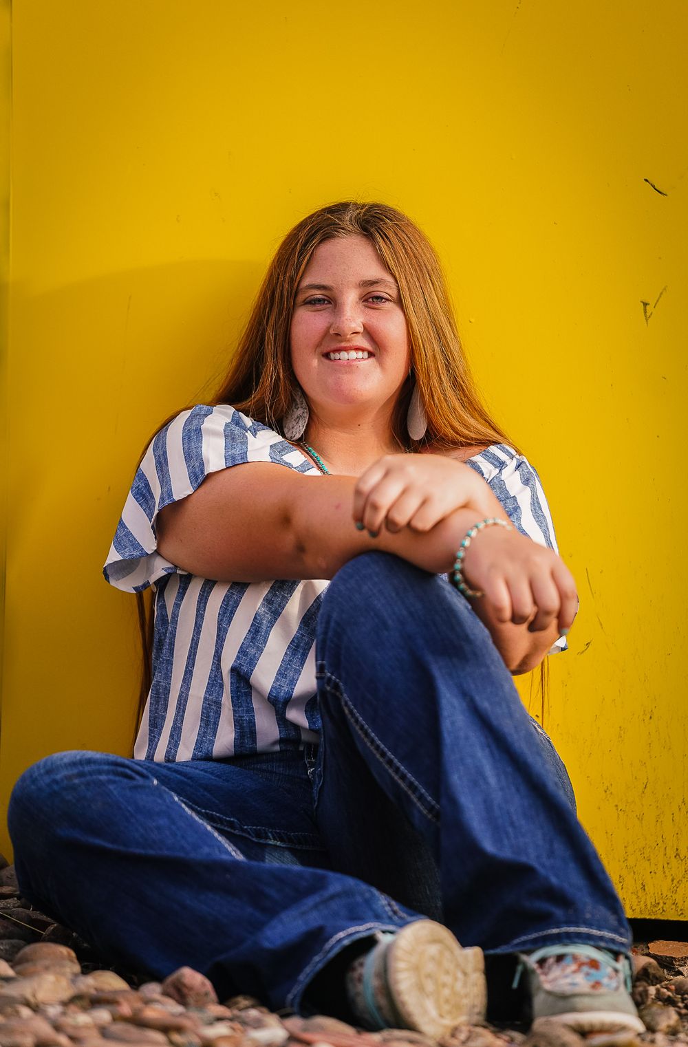 A casual portrait sequence against a vibrant yellow wall showing relaxed poses in denim and stripes.