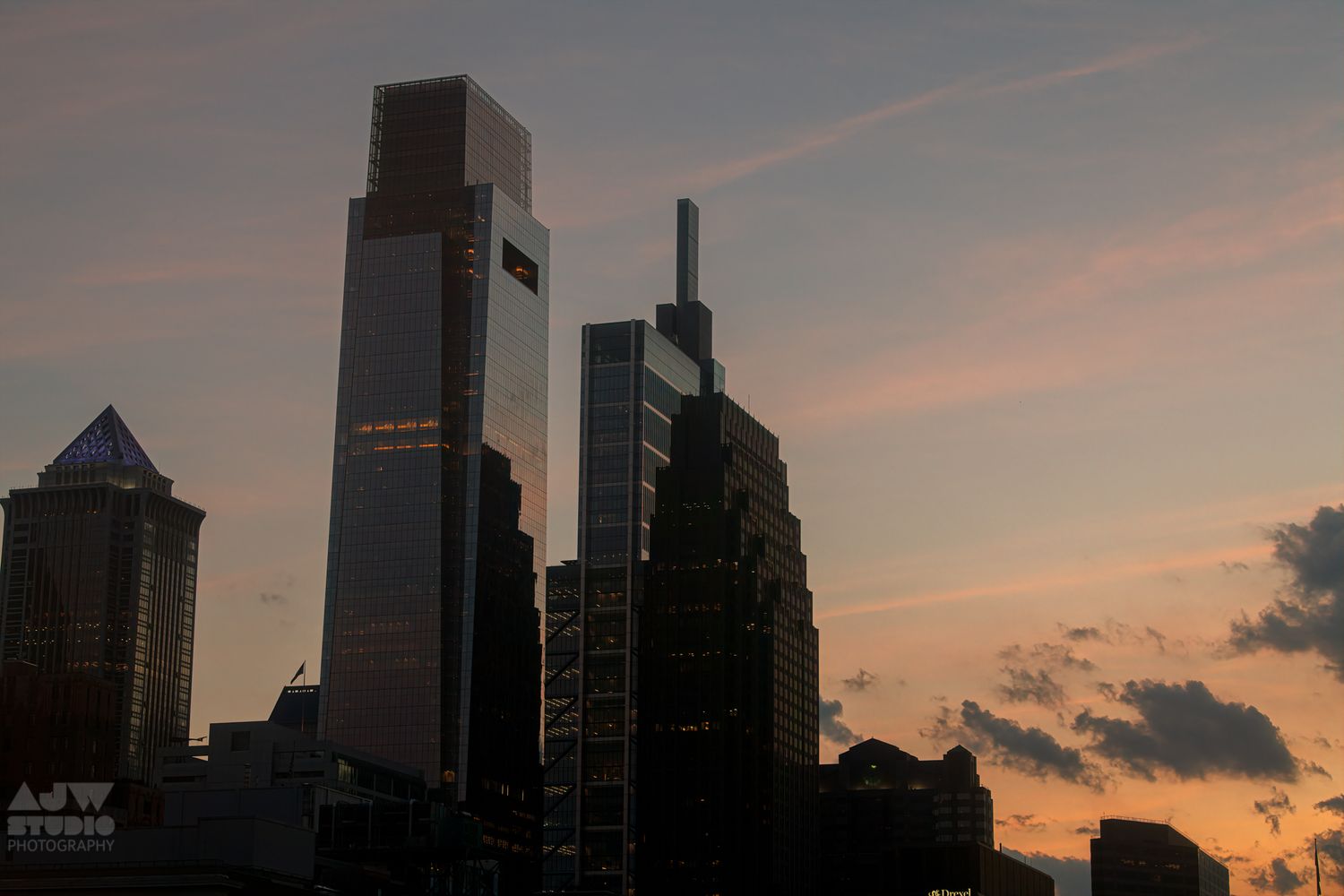 City skyline silhouetted against a sunset sky with tall skyscrapers.