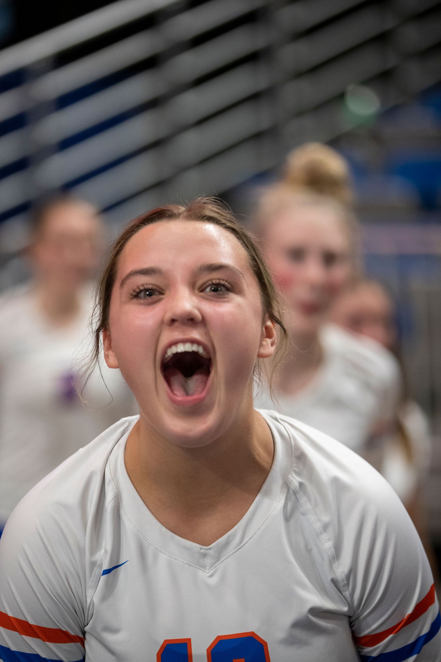 Athlete in white jersey shows pure joy and excitement during a sports celebration.