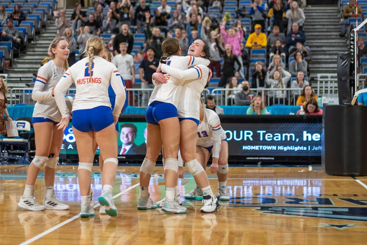 Volleyball players in action during competitive indoor match.