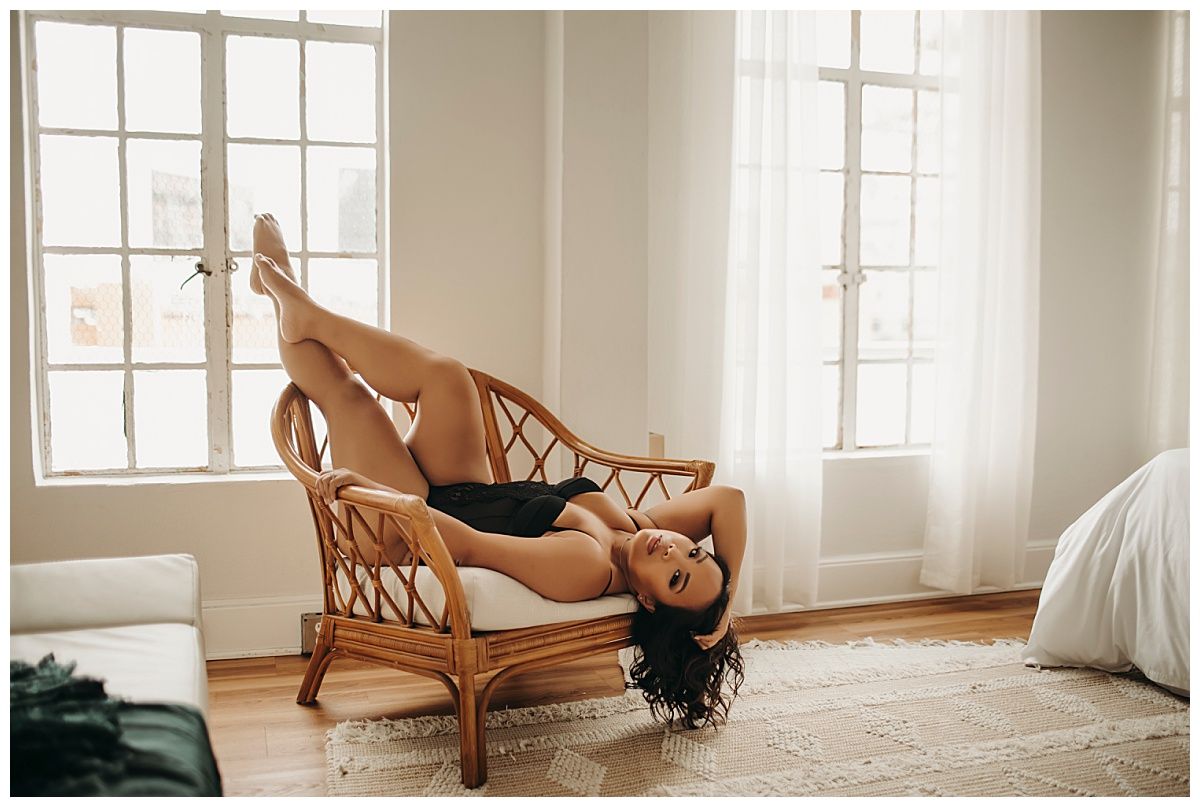 woman hangs head off edge of seat during empowering boudoir session
