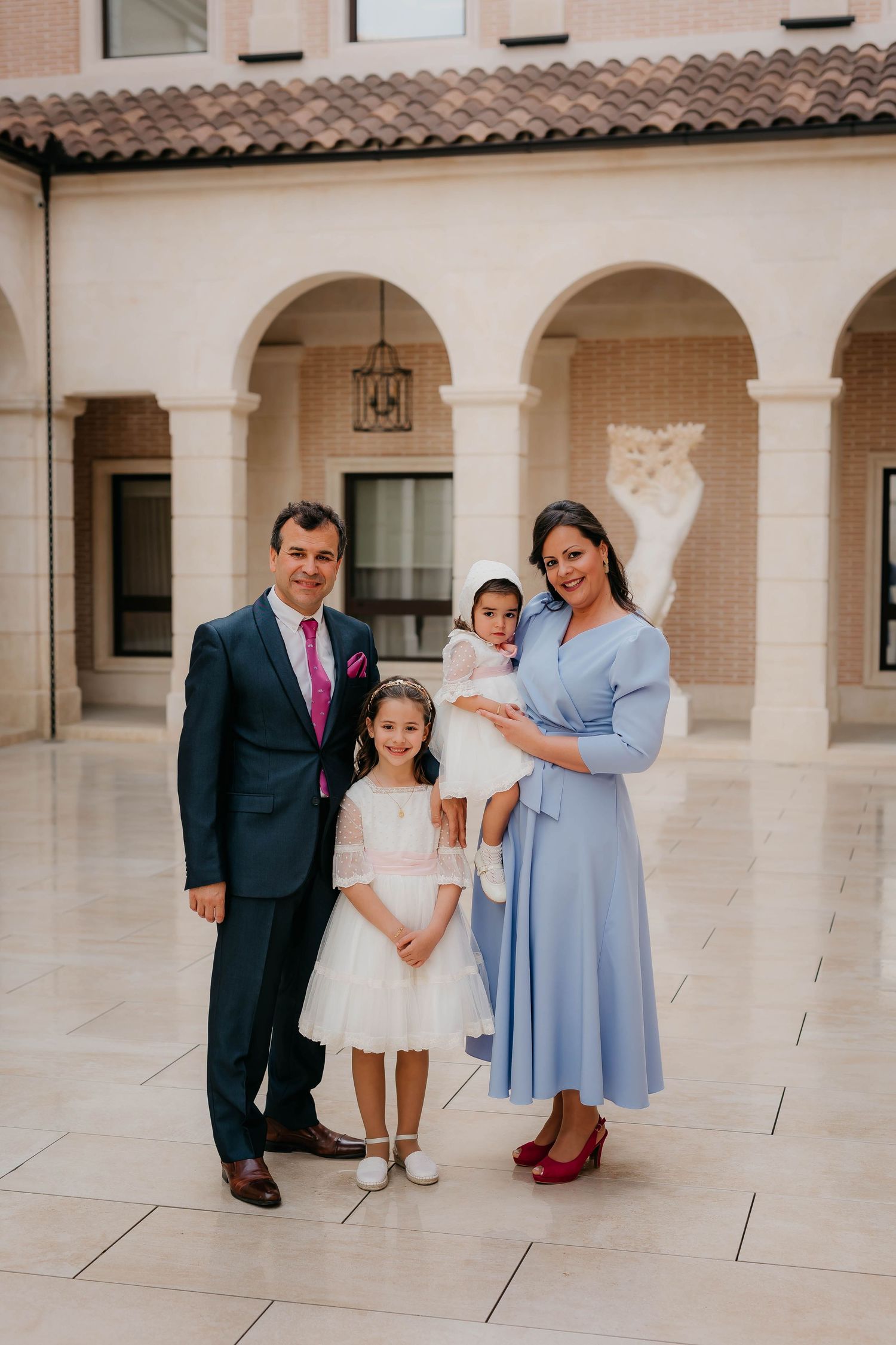 Fotografía de familia en el dia del bautizo de su niña pequeña