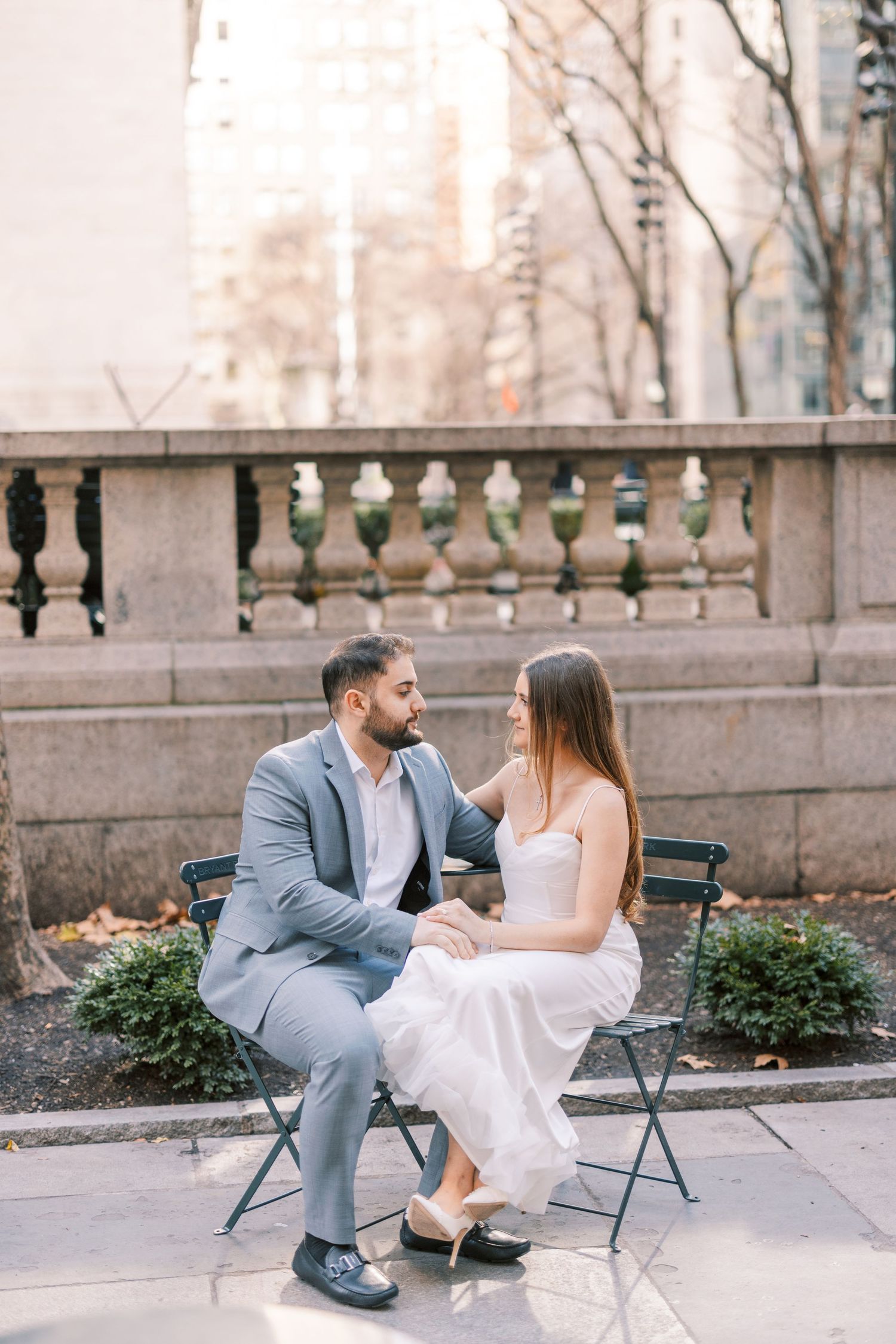 Bride and groom sitting on garden bench sharing a tender moment.