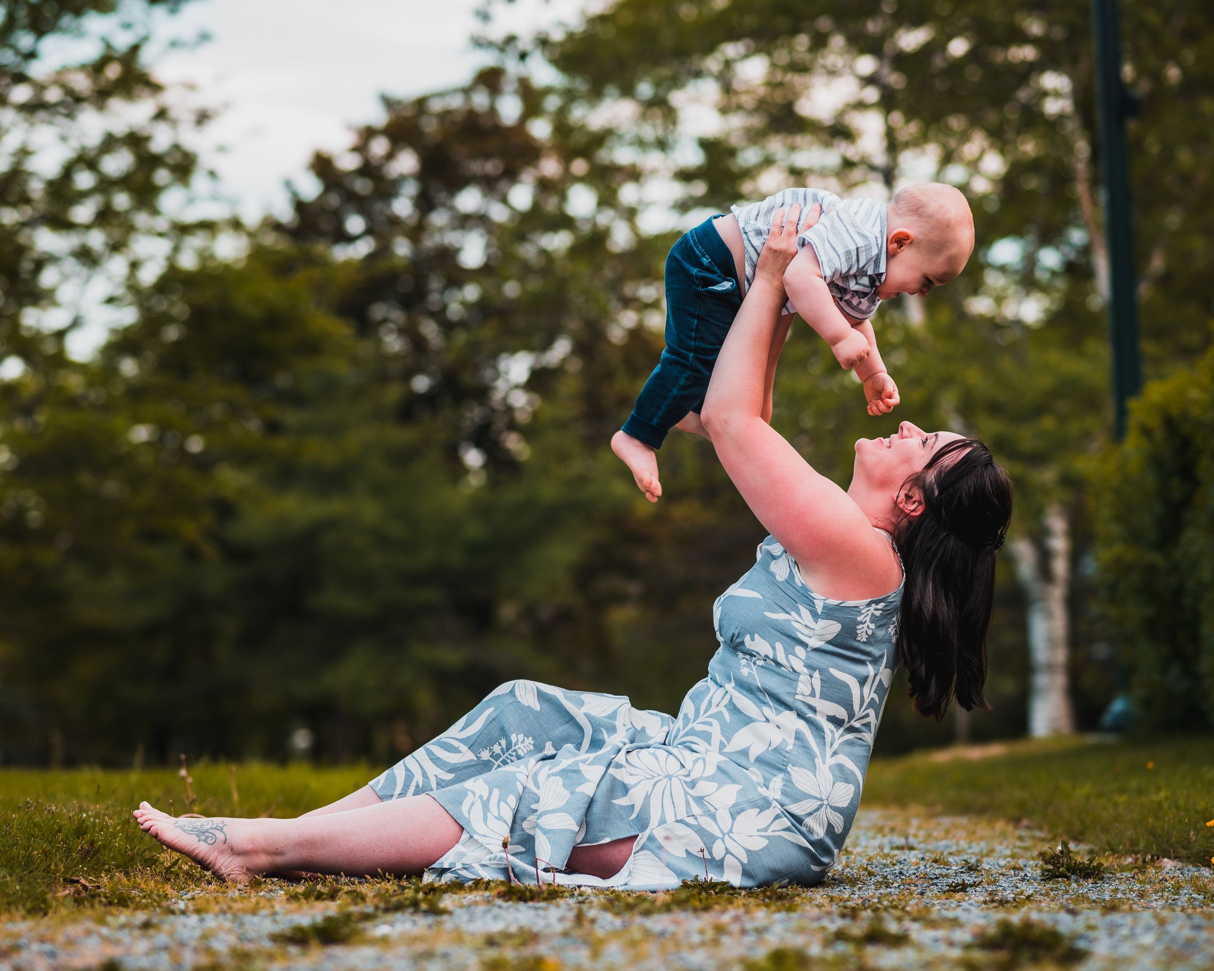 Joyful interaction between parent and child in casual denim outfits outdoors.