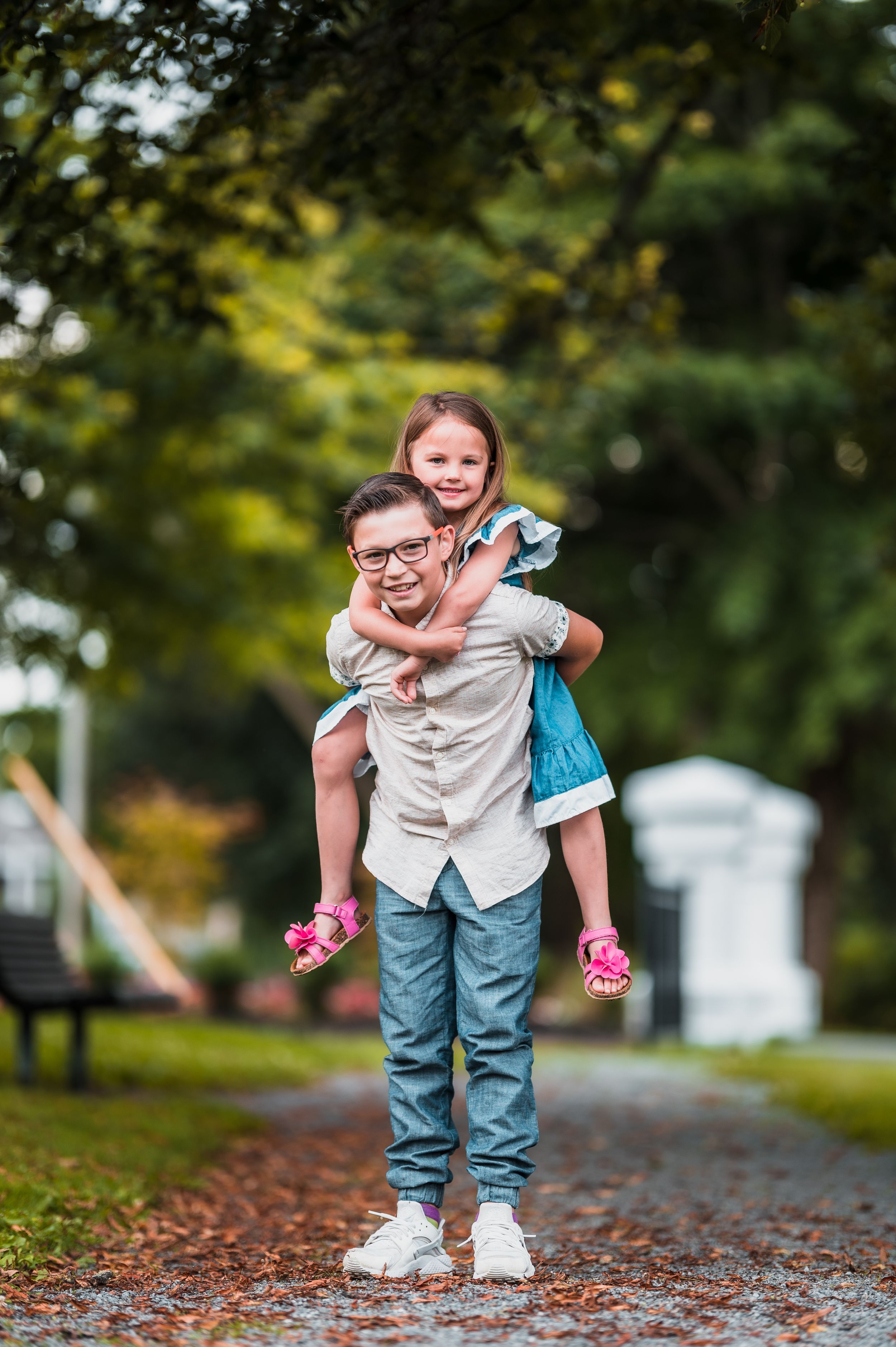 Playful moments captured on a tree-lined path with matching outfits and joyful expressions.