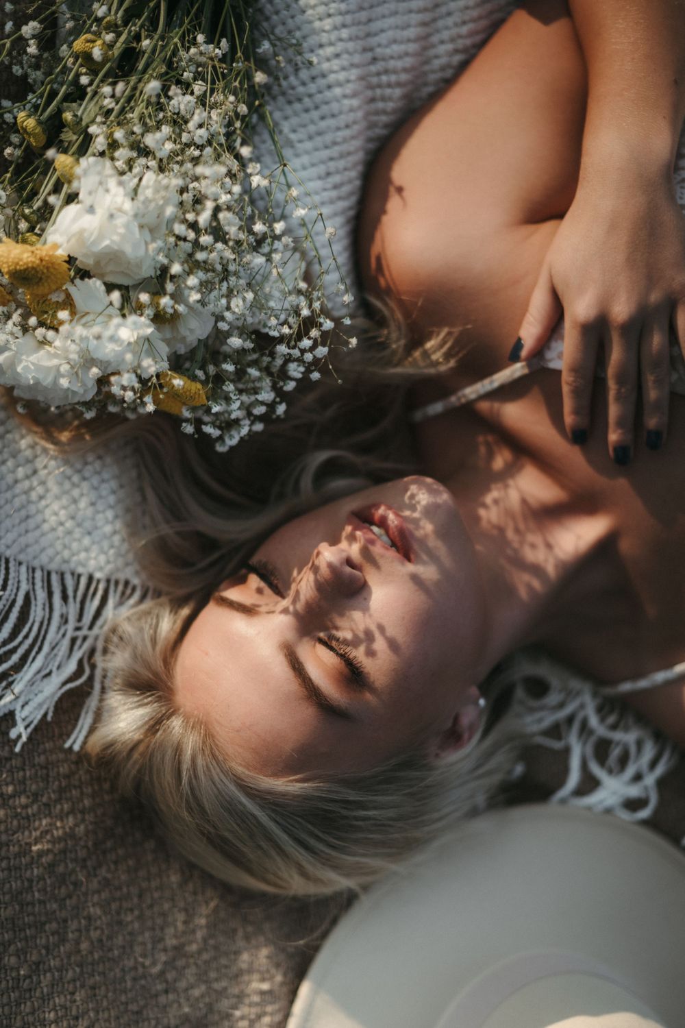 Artistic portrait with baby's breath flowers and soft lighting on textured fabric.