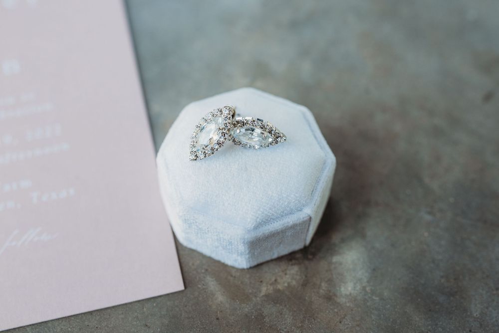 Diamond engagement ring resting on white hexagonal display box.
