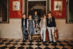 Children in Château de Sable clothing, posed facing the camera at a hotel entrance in Morocco, capturing stylish lookbook moments.