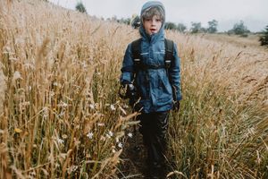 Child enjoying a rainy day in the wild wearing a Patagonia jacket, embracing outdoor adventure and connection with nature.