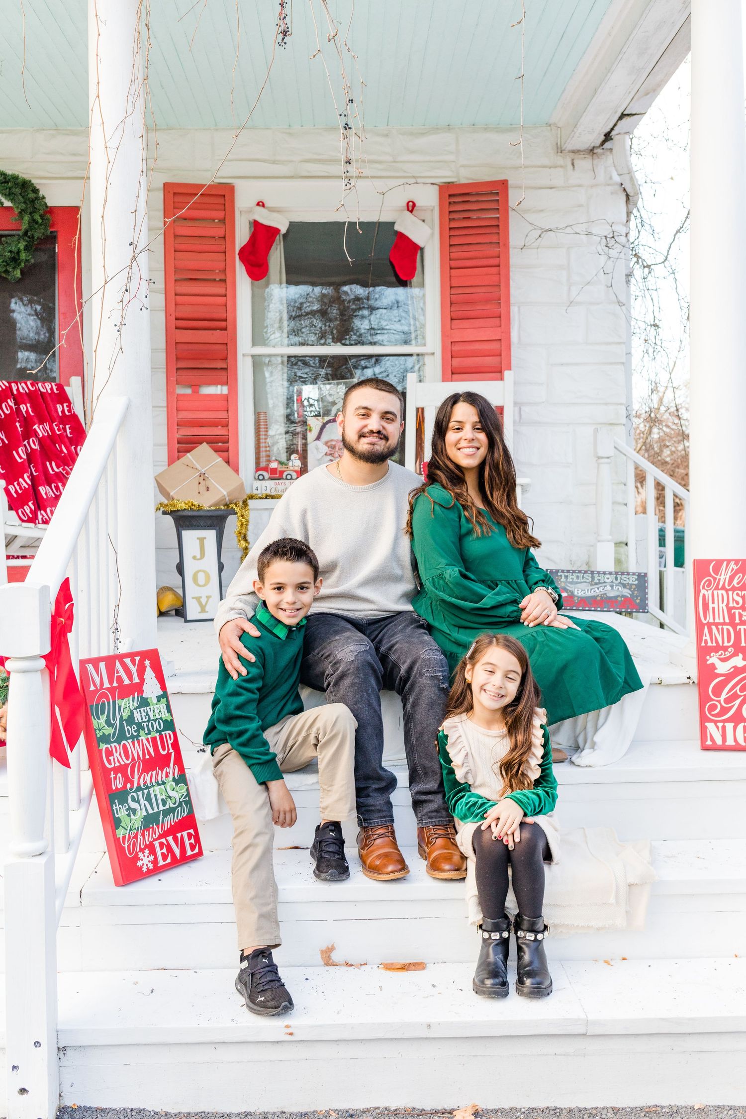A family adorned in festive attire, posing with holiday decorations in the scenic Hudson Valley