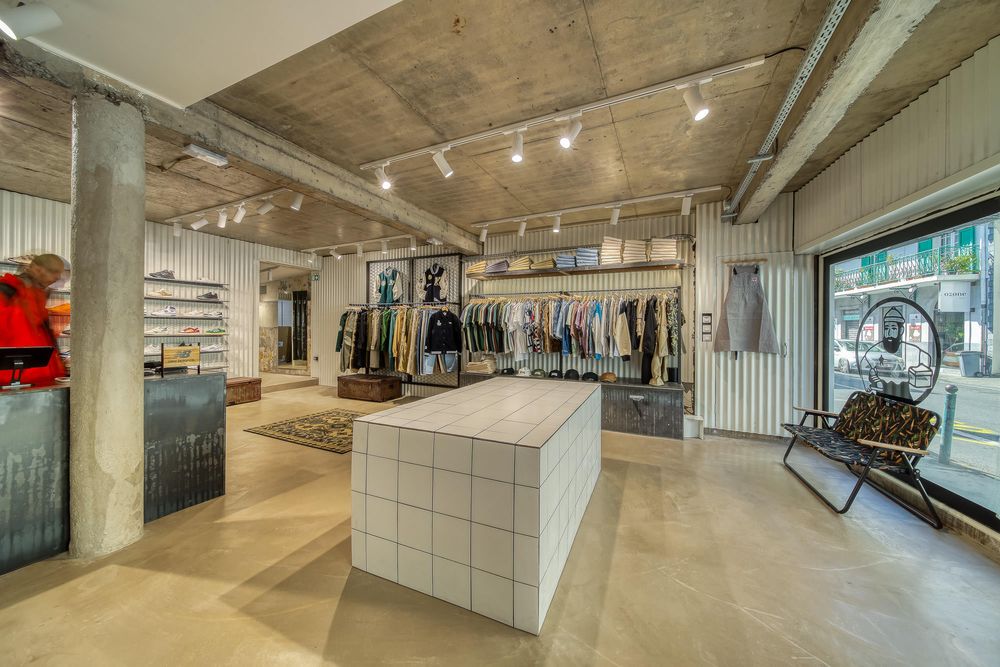 Modern industrial retail space with concrete floors and exposed ceiling beams.
