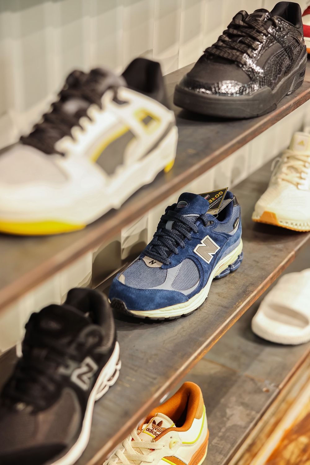 Collection of athletic and casual sneakers displayed on wooden shelving.