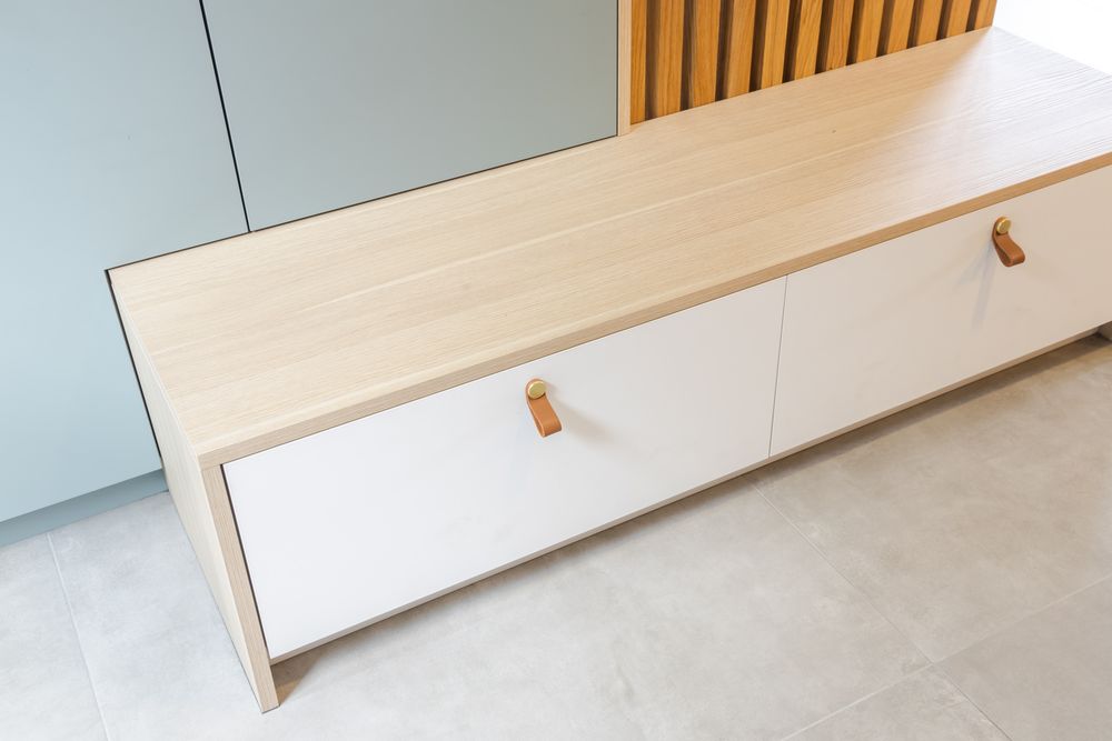 Minimalist interior with wooden slat details and built-in storage featuring clean lines and light colors.