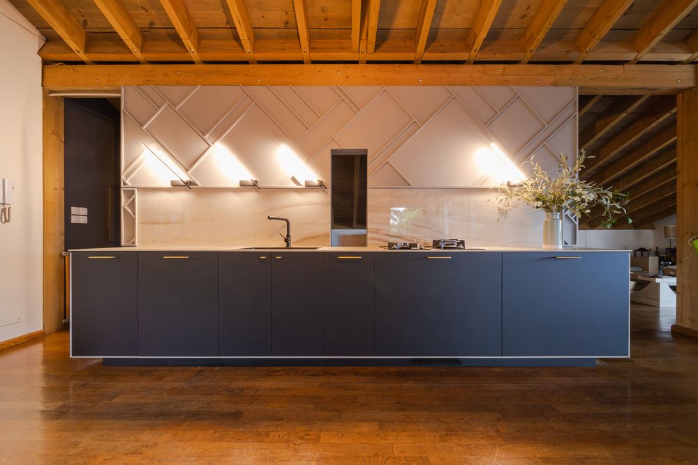 Modern industrial office space with exposed wooden beams and sleek black cabinetry.