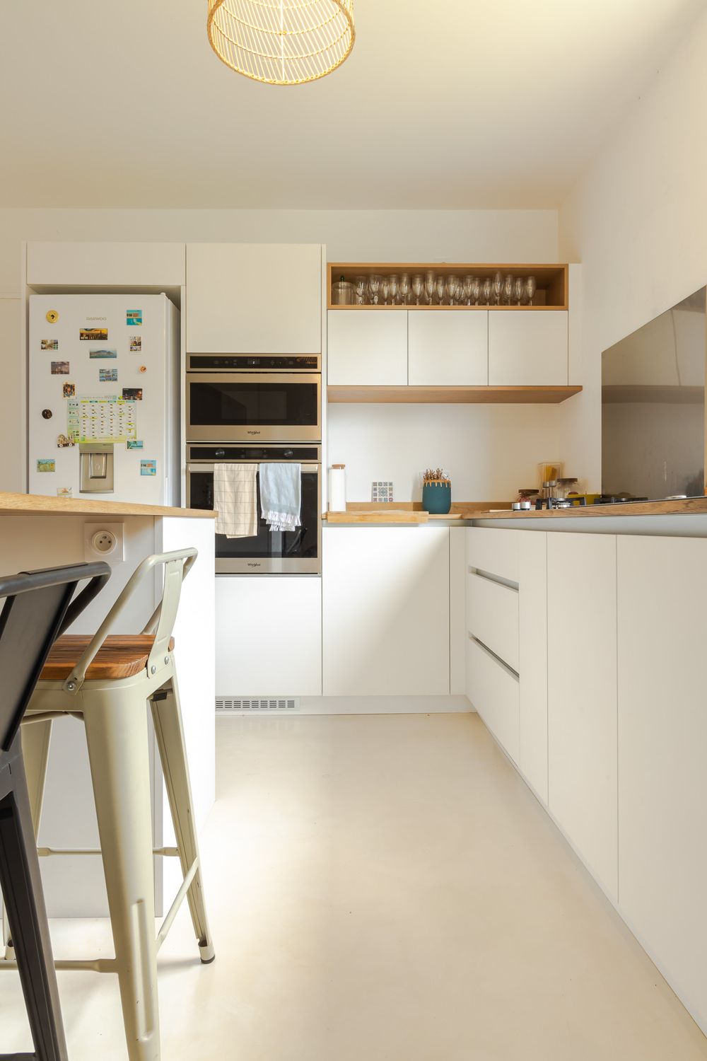 Minimalist white kitchen design with wooden accents and floating shelves creating a clean aesthetic.