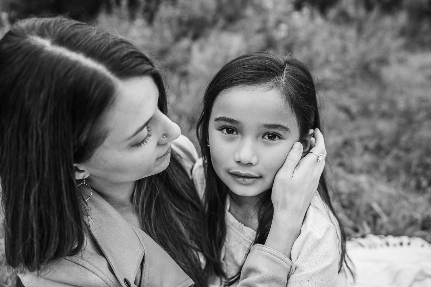 Mother putting daughter's hair behind her ear