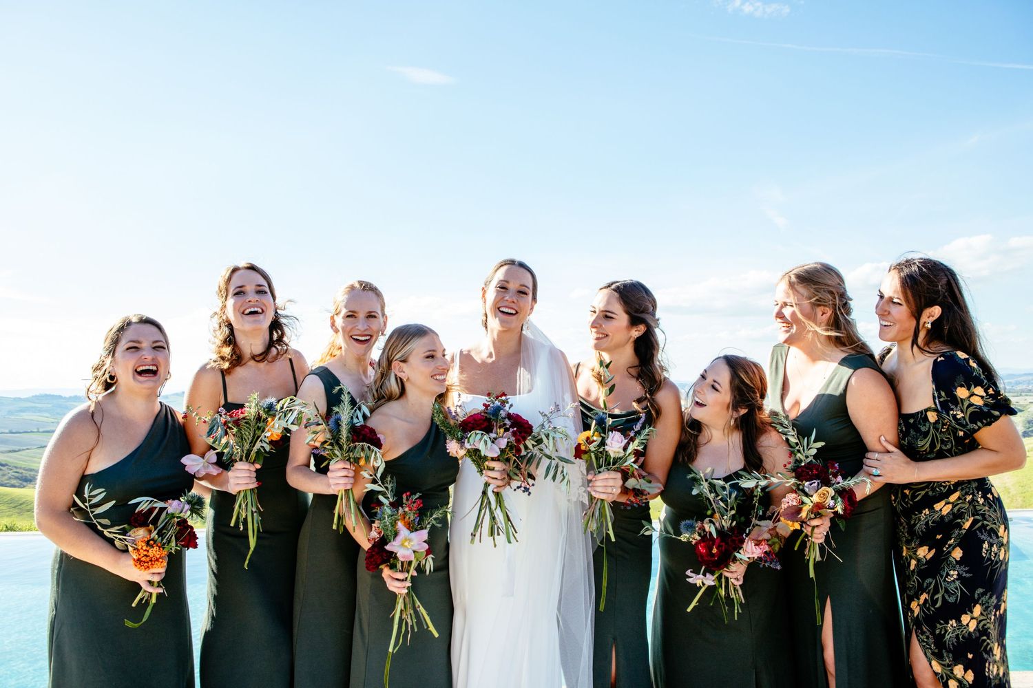 The bride and bridesmaids all smiling together at this destination wedding near Siena.