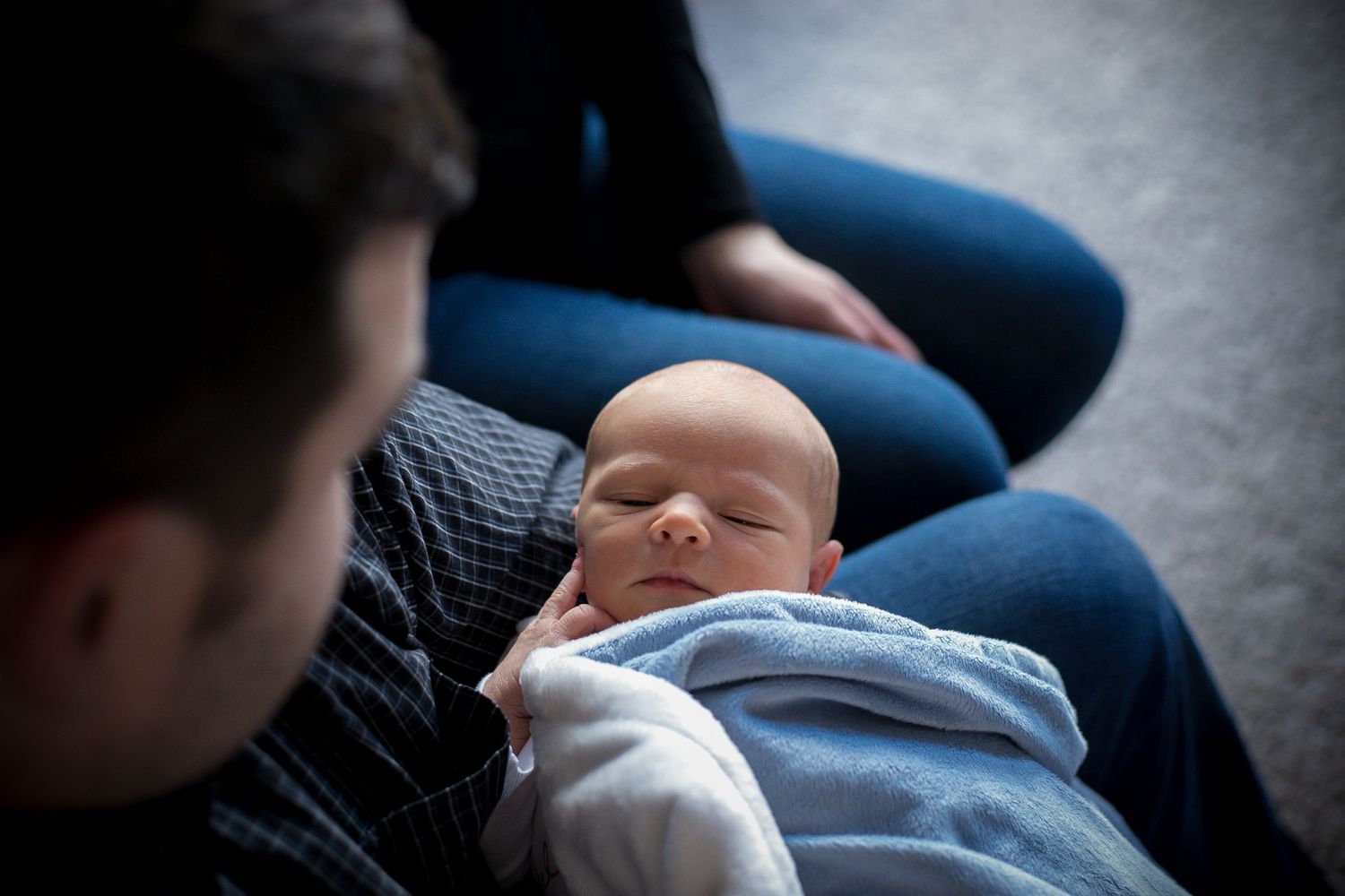 Dad holding his newborn son during their in-home newborn session in Sioux City, IA.