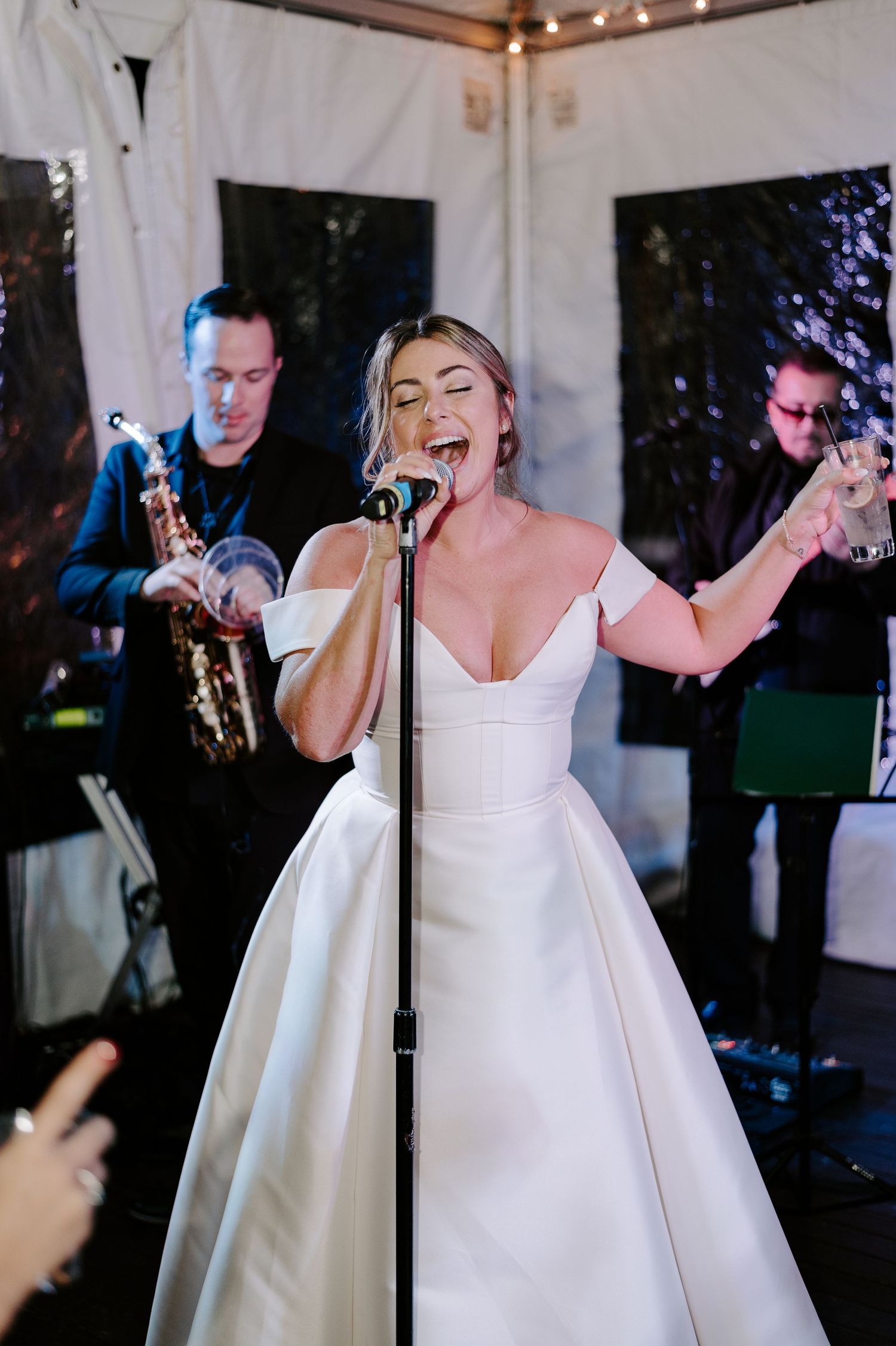 A couple shares a playful dance moment in formal attire at their wedding reception.