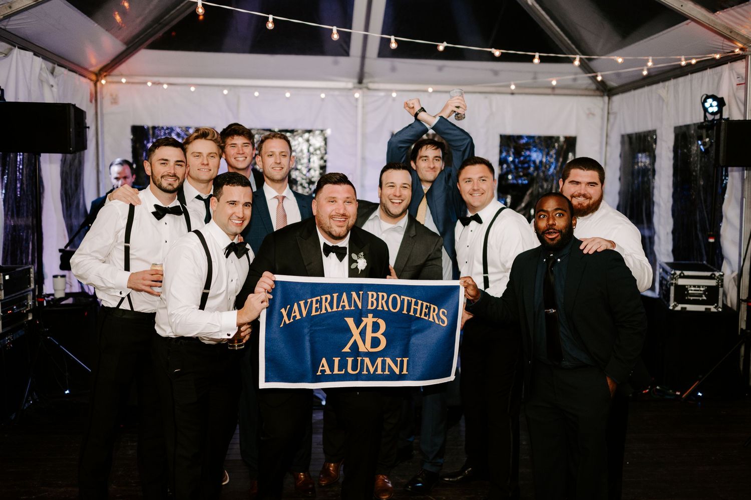 Wedding reception venue with alumni banners displayed and guests gathered underneath.
