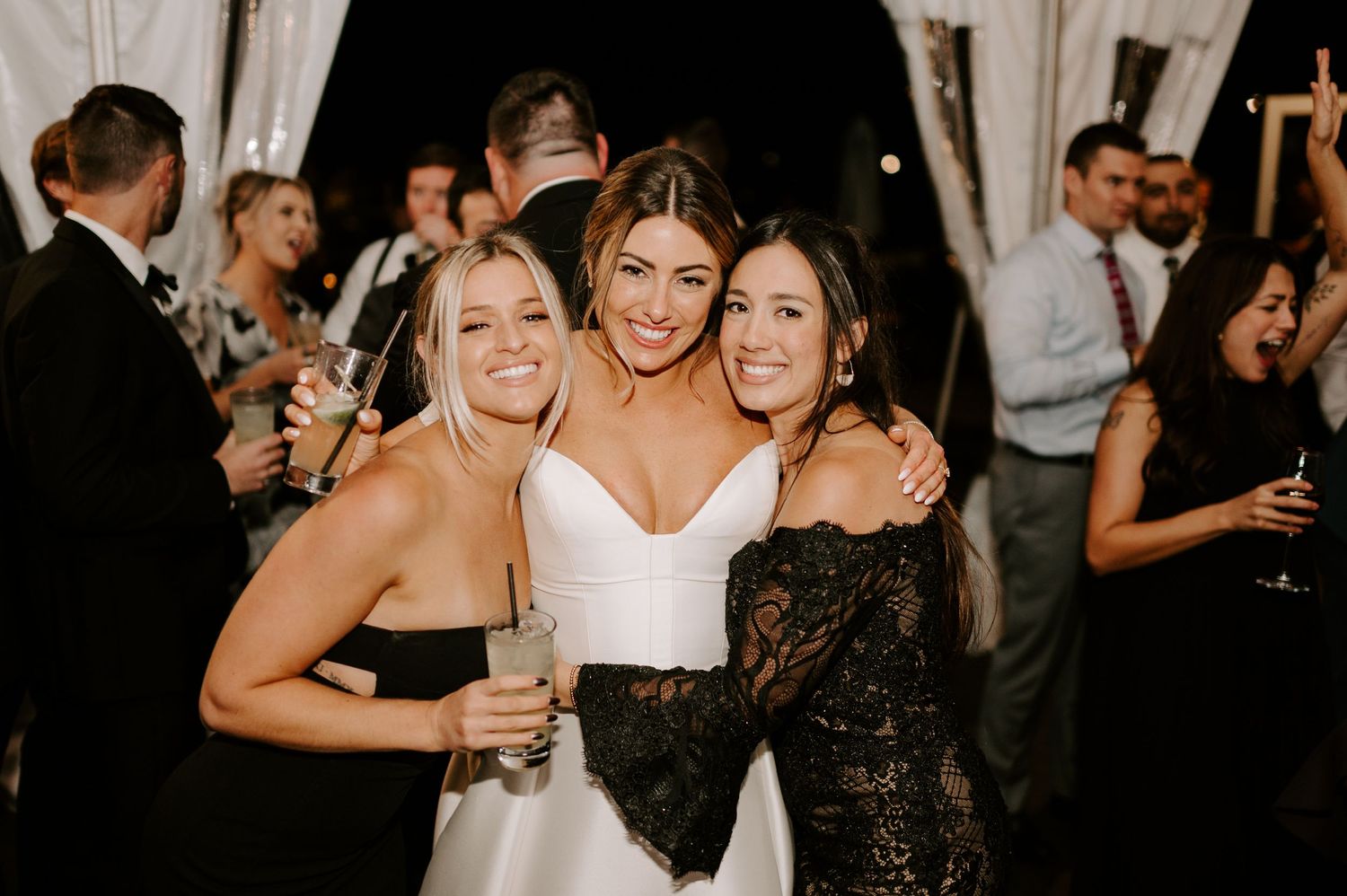 Wedding guests enjoying themselves on a lively dance floor at an evening celebration.