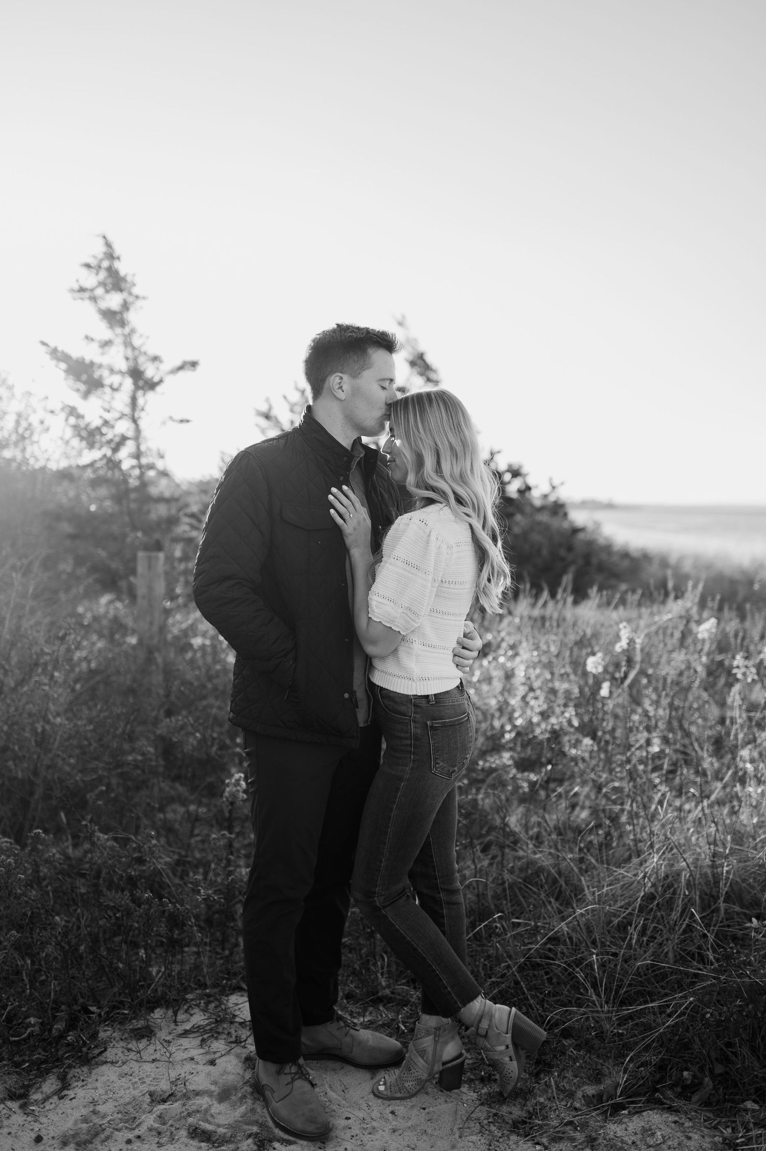 Black and white photos capture romantic moments between a couple in a natural outdoor setting.