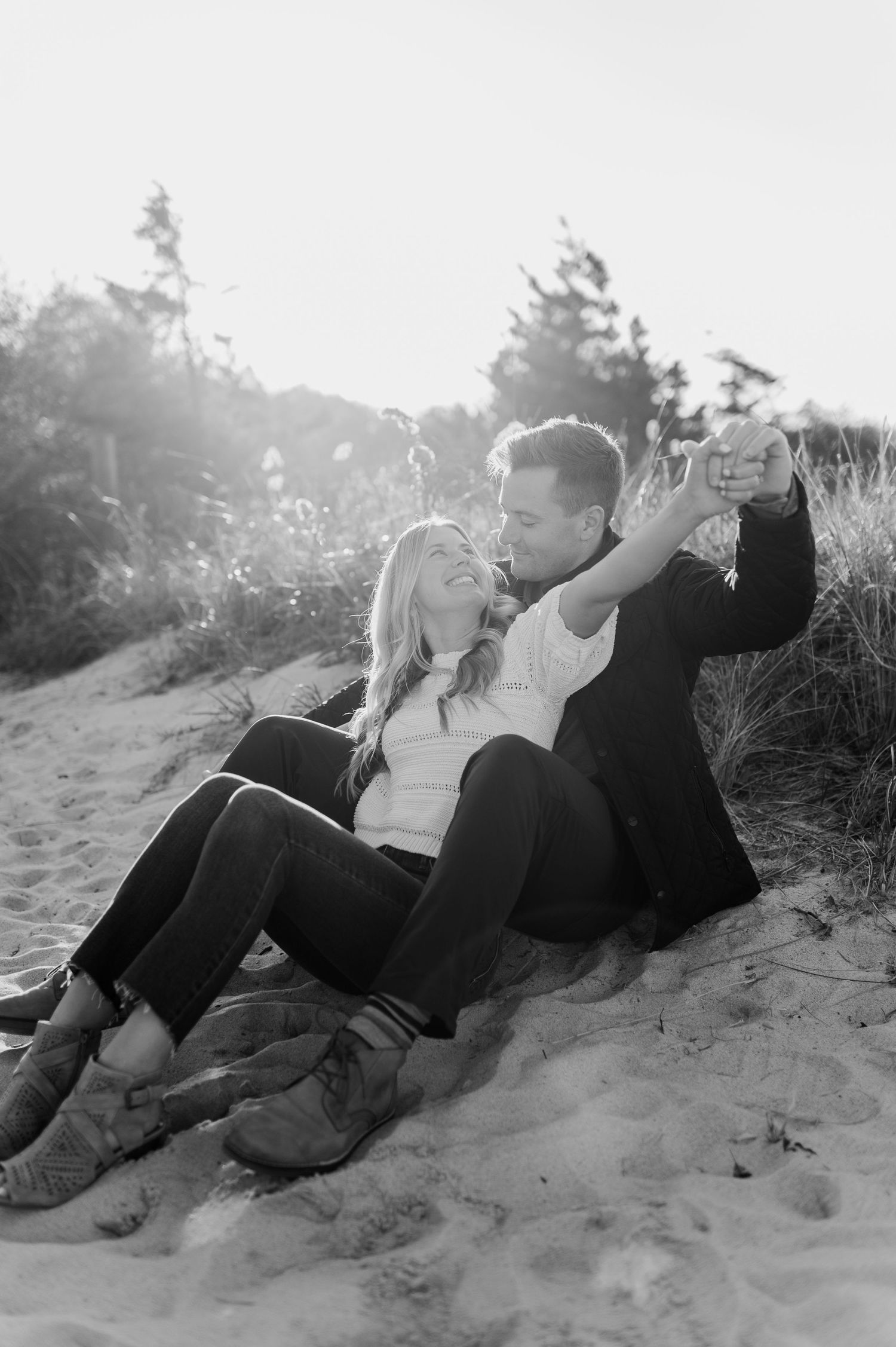 A series of black and white photos shows a couple sharing tender moments on a sandy hillside.