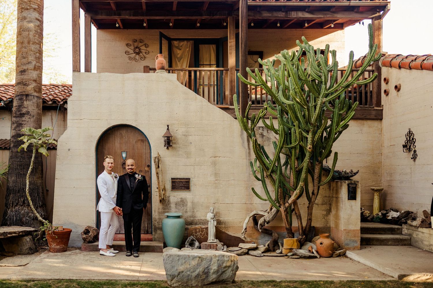 A courtyard entrance with southwestern architecture and large desert plants.